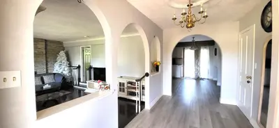a large living room with a chandelier and a hallway at Cozy Home Close to Attractions in Niagara Falls in Thorold