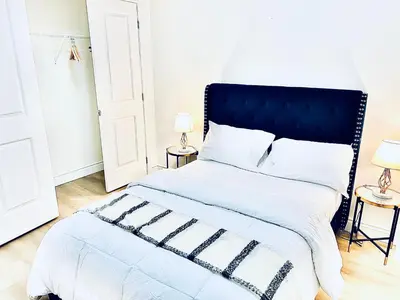 a bedroom with a large bed with a blue headboard at LaVida Exclusive Guest House (Rm #3) in London