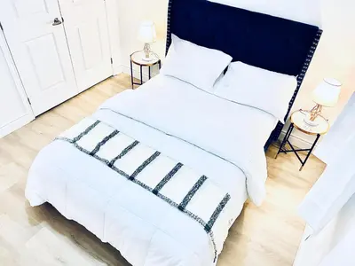 a white bed with a black headboard and white sheets at LaVida Exclusive Guest House (Rm #3) in London