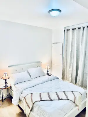 a white bedroom with a large bed and two lamps at LaVida Exclusive Guest House(Rm#4) in London