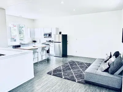 a living room with a couch and a kitchen at LaVida Exclusive Guest House(Rm#4) in London