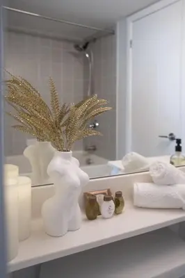 a white vase with a plant on a shelf in a bathroom at Downtown Toronto Condo Parking Sleeps 4 Balcony Walk to Lake in Toronto