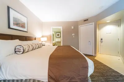 a bedroom with a large white bed and a bathroom at Horseshoe Valley Suites - The Maple in Shanty Bay