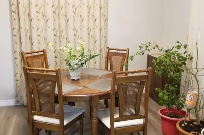 a table and chairs with a vase of flowers on it at Cozy Luxurious Detached 4 Bedroom House in Guelph