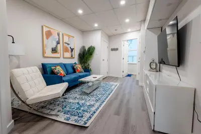 a living room with a blue couch and a tv at Victoria's Lookout in London