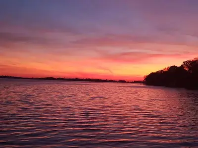 a sunset over a large body of water at West Lake Waterfront Swimming - Free Pontoon Boat! in West Lake