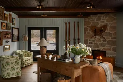 a living room with a table and a fireplace at The June Motel, Beaver Valley in Kimberley