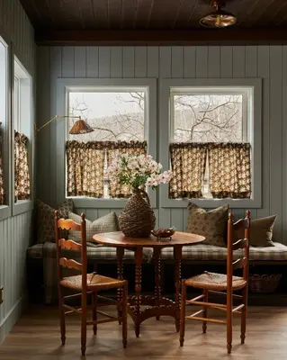 a dining room with a table and two windows at The June Motel, Beaver Valley in Kimberley
