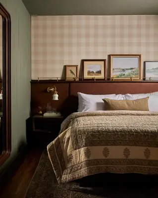a bedroom with a bed and some pictures on the wall at The June Motel, Beaver Valley in Kimberley