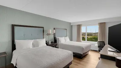 a hotel room with two beds and a window at Hampton Inn & Suites by Hilton Toronto Markham in Markham