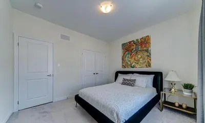 a bedroom with a bed and a painting on the wall at Beatrice Beach House in Wasaga Beach
