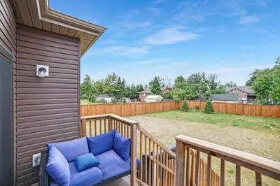a porch with a blue chair on a wooden deck at Beatrice Beach House in Wasaga Beach