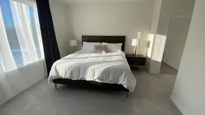 a bedroom with a bed and a large window at Beatrice Beach House in Wasaga Beach