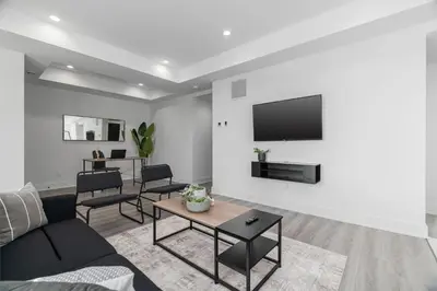 a living room with a couch and a tv on a wall at Rent 8Bed 8Bath DowntownLondon Parking Wi-Fi in London