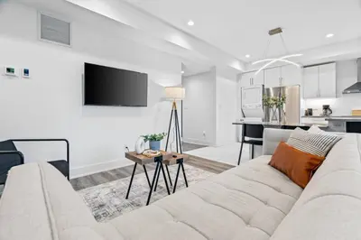 a living room with a white couch and a kitchen at Rent 8Bed 8Bath DowntownLondon Parking Wi-Fi in London