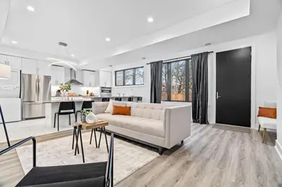a living room with a white couch and a kitchen at Rent 8Bed 8Bath DowntownLondon Parking Wi-Fi in London