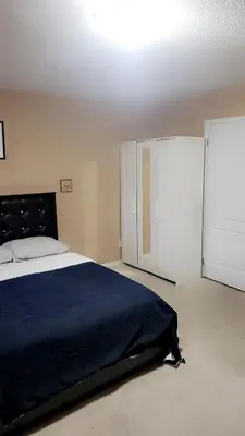 a bedroom with a large bed and a closet at Cozy jets empire in Brampton