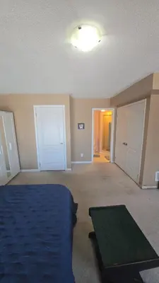 a bedroom with a bed and a table in it at Cozy jets empire in Brampton