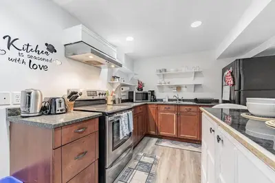 a large kitchen with wooden cabinets and stainless steel appliances at Cozy Haven Retreat 2Bed Basement in Whitby