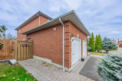 a red brick house with a white garage at Cozy Haven Retreat 2Bed Basement in Whitby