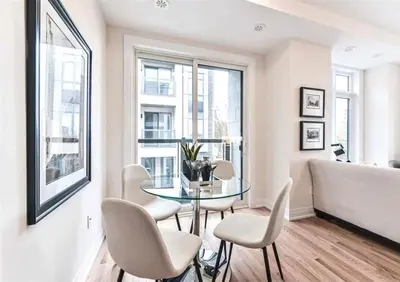 a dining room with a glass table and white chairs at Luxe Toronto Townhome, Rooftop Terrace, Parking in Toronto