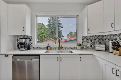 a white kitchen with a sink and a window at Dorado at The Kabins by The Falls in Fenelon Falls