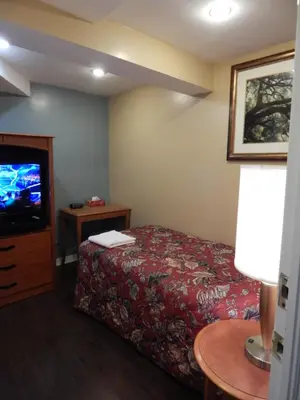 a hotel room with a bed and a tv at Nox Hostel in Toronto