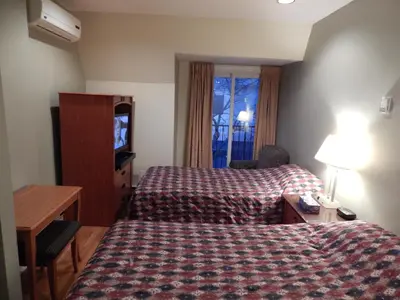 a hotel room with a bed and a desk and a television at Nox Hostel in Toronto
