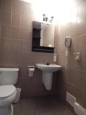 a bathroom with a toilet and a sink and a mirror at Nox Hostel in Toronto