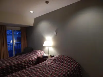 a hotel room with two beds and a lamp at Nox Hostel in Toronto