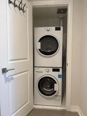 a washer and dryer in a small room with a door at Cozy holiday home in Toronto