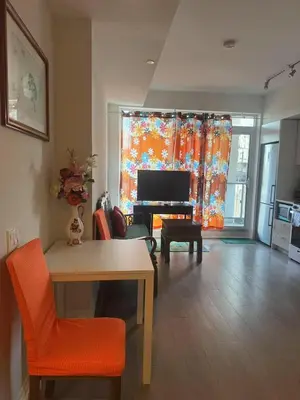 a living room with a television and a table and chairs at Cozy holiday home in Toronto