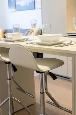 a white table with two glasses and a chair at Downtown Charm 2BR Retreat in Prime Location in Toronto