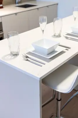 a white kitchen table with glasses and utensils at Downtown Charm 2BR Retreat in Prime Location in Toronto