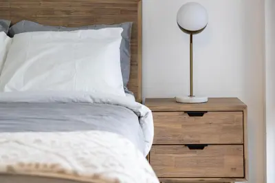 a bedroom with a bed and a lamp on a nightstand at Downtown Charm 2BR Retreat in Prime Location in Toronto