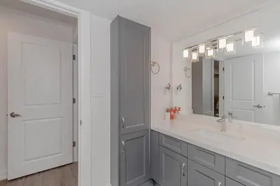 a white bathroom with a sink and a mirror at Luxury Basement Apartment in Oakville Monthly stays only in Oakville