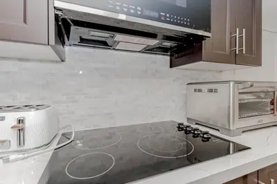 a kitchen with a stove top and a microwave at Luxury Basement Apartment in Oakville Monthly stays only in Oakville