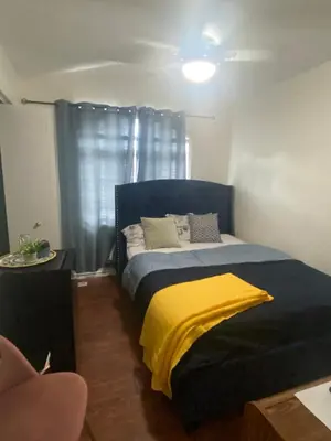 a bedroom with a blue bed with a yellow blanket at Spruce Lodge in London