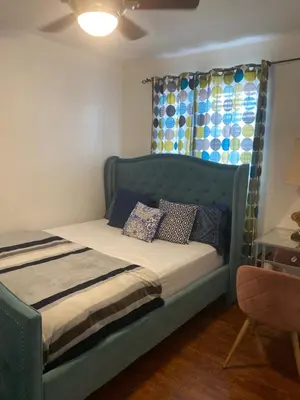 a bedroom with a blue bed with pillows on it at Spruce Lodge in London