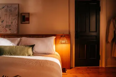 a bedroom with a bed with a light next to a door at Somewhere Inn Collingwood in Collingwood