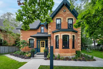 a red brick house with a black roof at Somewhere Inn Collingwood in Collingwood
