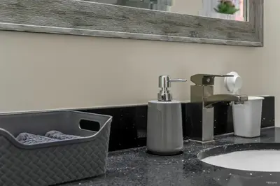 a bathroom counter with a sink and a mirror at Luxury Renovated House in Prime Location with Parking in Toronto