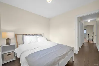 a white bedroom with a bed and a hallway at Luxury Renovated House in Prime Location with Parking in Toronto