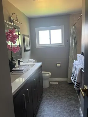 a bathroom with a sink and a toilet and a window at Bright & Cozy 4BR Home for Your Family Stay With Optional Pool Access in Mississauga