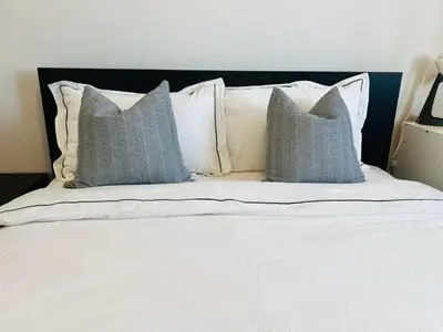 a bed with three pillows on top of it at Luxury Oakville Home, Hot Tub, Fireplace, New Home in Oakville