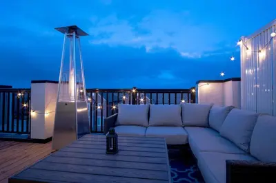 a white couch sitting on a balcony at night at Modern 4-Bed Townhome with Cinema & Roof Terrace in Oakville