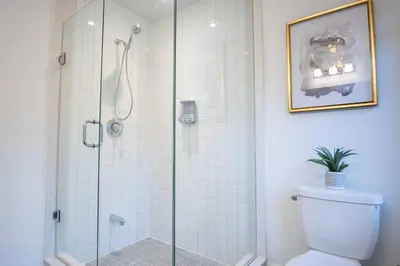 a bathroom with a glass shower with a toilet at Modern 4-Bed Townhome with Cinema & Roof Terrace in Oakville
