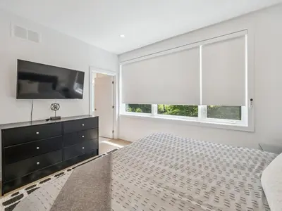 a bedroom with a television and a large window at Luxury Resort Villa in Muskoka in Gravenhurst