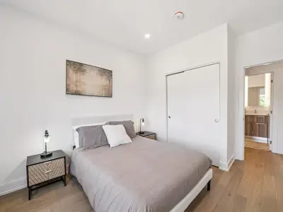 a white bedroom with a large bed and a table at Luxury Resort Villa in Muskoka in Gravenhurst