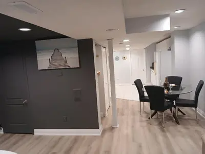 a dining room with a table and black chairs at Furnished calm basement studio apartment in Mississauga